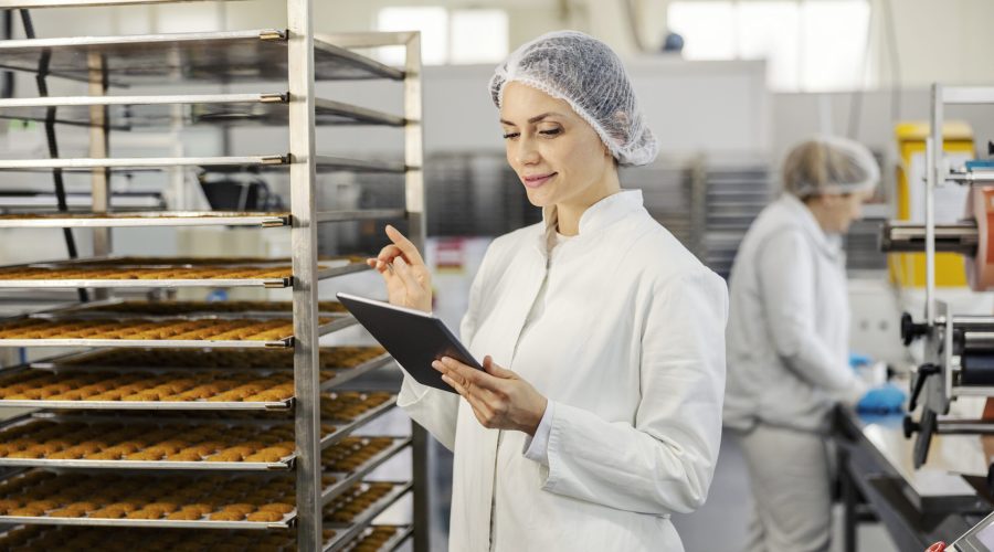 A quality controller is doing control of cookies in food factory.