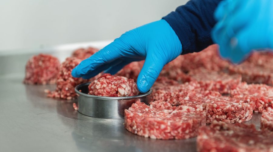 Hand of a chef preparing burgers, close up